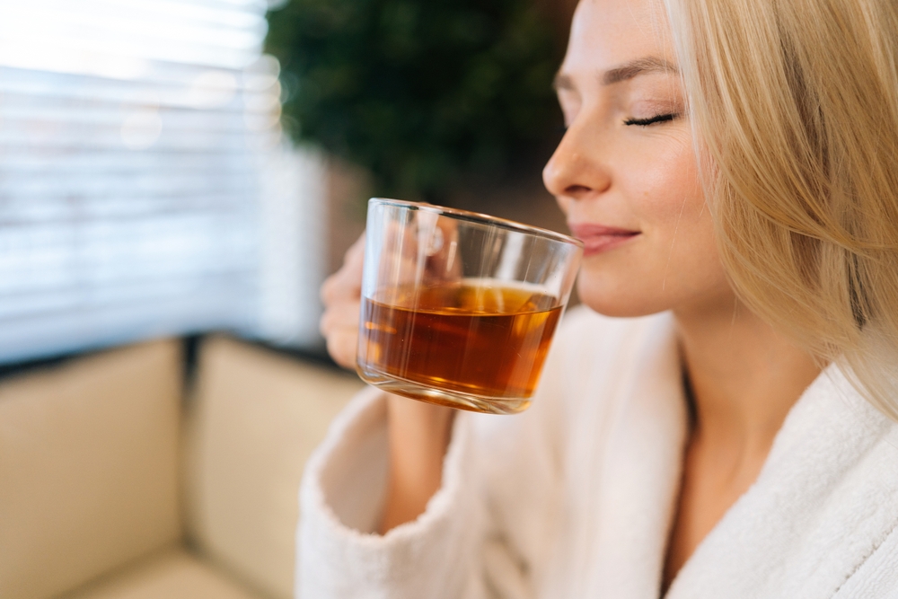 woman sipping tea and taking care of her holistic health